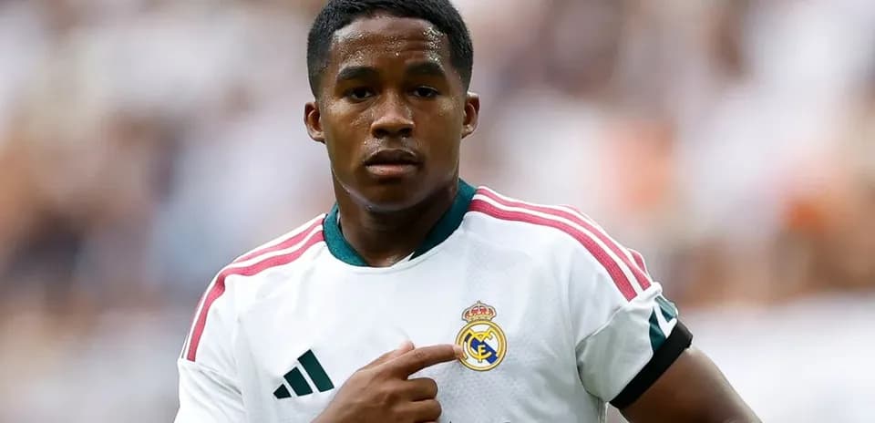 Player pointing to Real Madrid crest on jersey