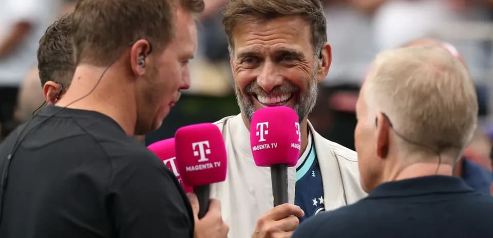 Four commentators discussing with microphones at event