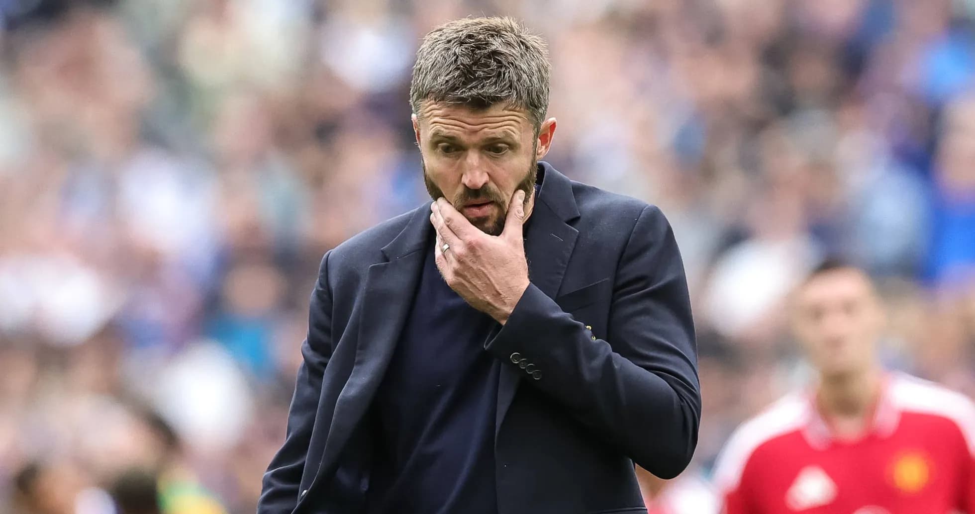 Coach with hand on chin during match