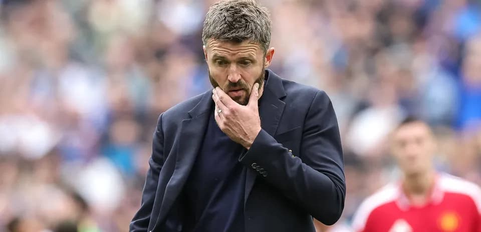 Coach with hand on chin during match