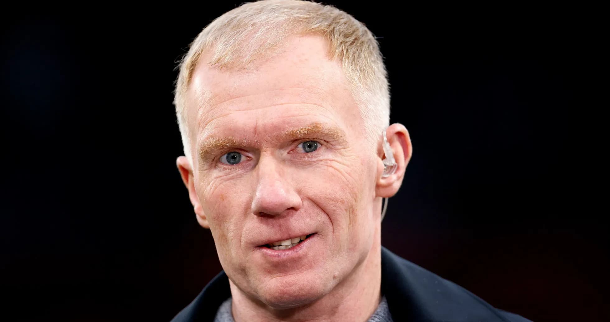 Person with short hair and earpiece speaking