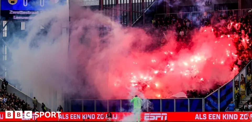 Fans lighting flares during a football match