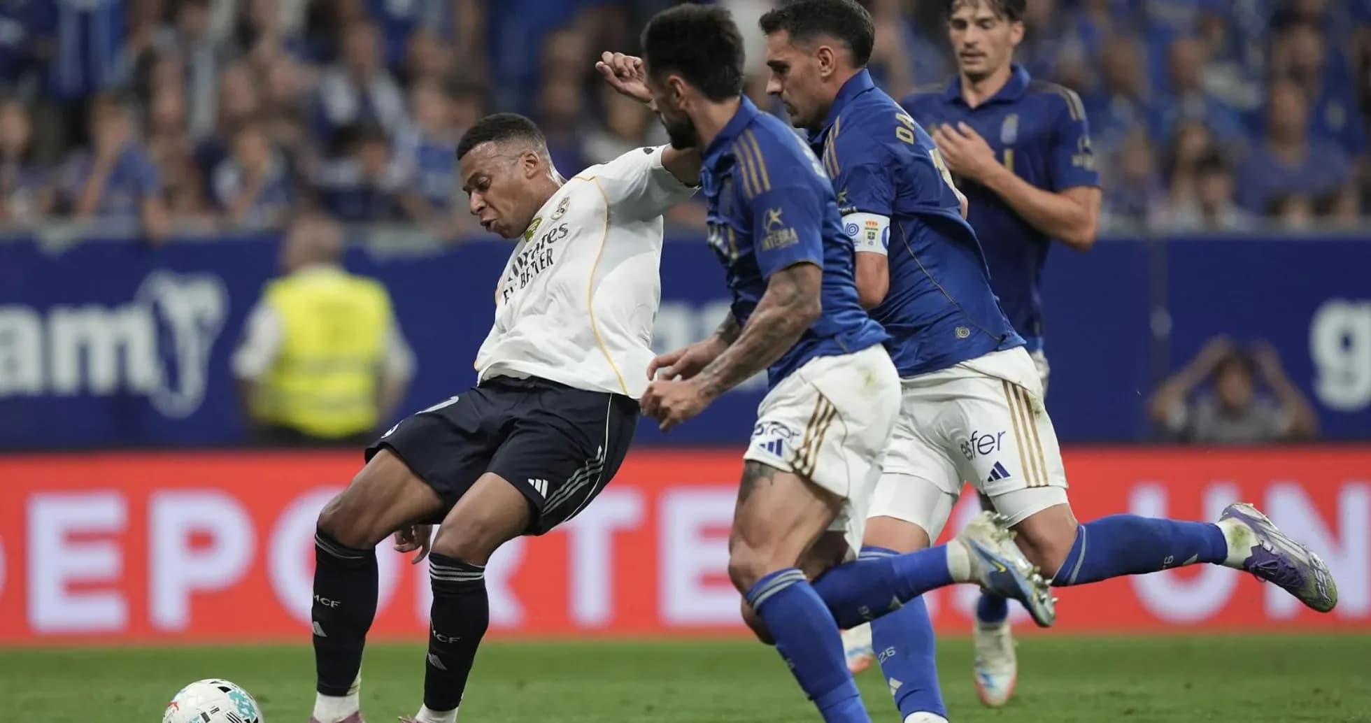 Mbappe challenged by Oviedo players during match