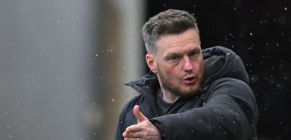 Coach gesturing during match in rainy weather