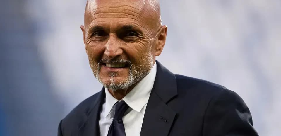 Coach smiling in a suit on the field