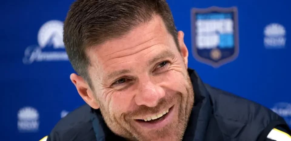 Coach smiling at press conference backdrop
