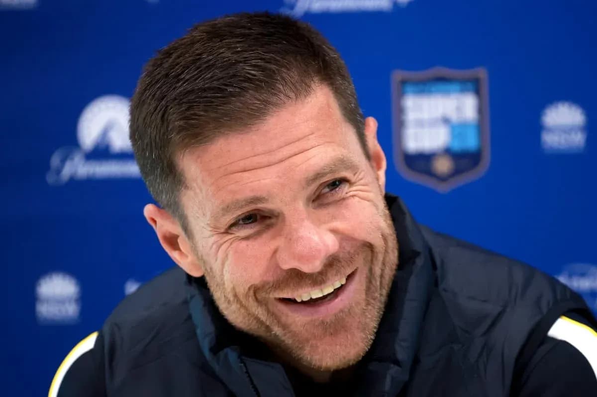 Coach smiling at press conference backdrop