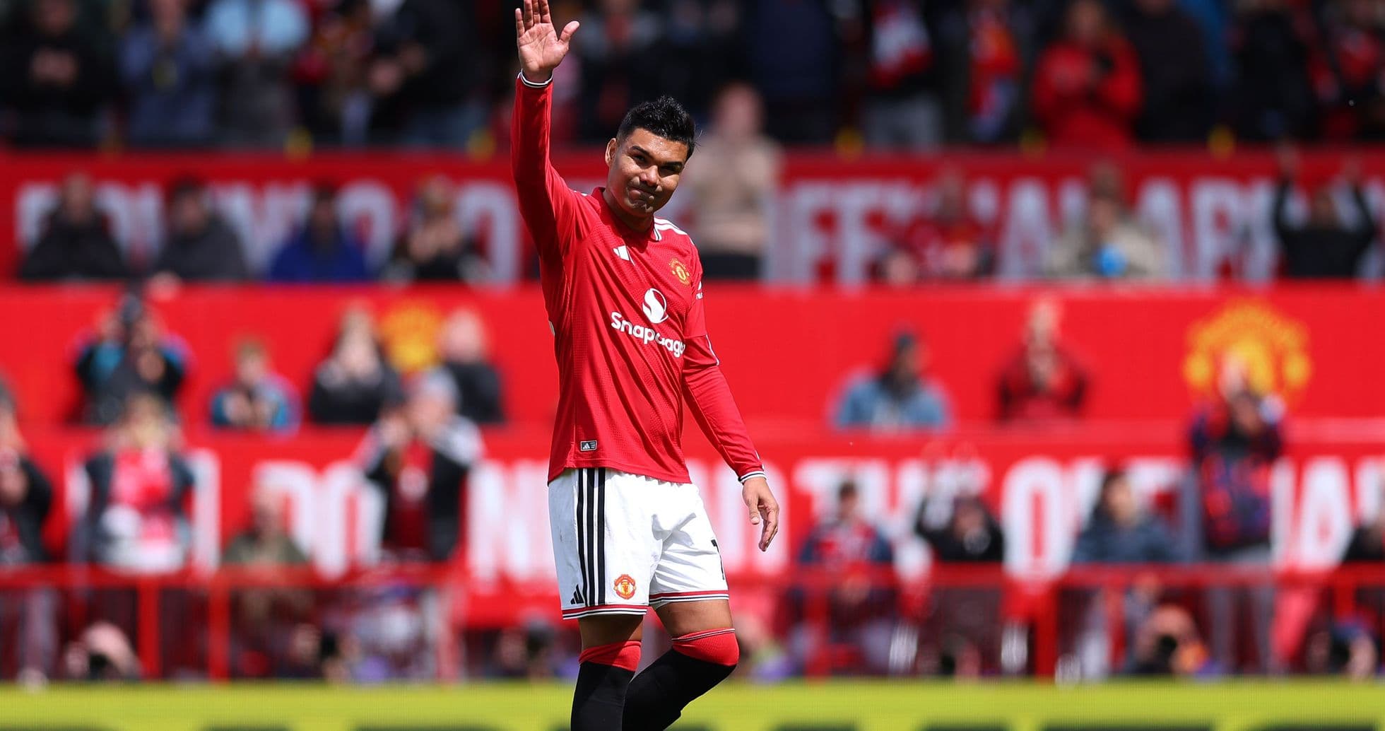 Player waving to fans at Old Trafford stadium