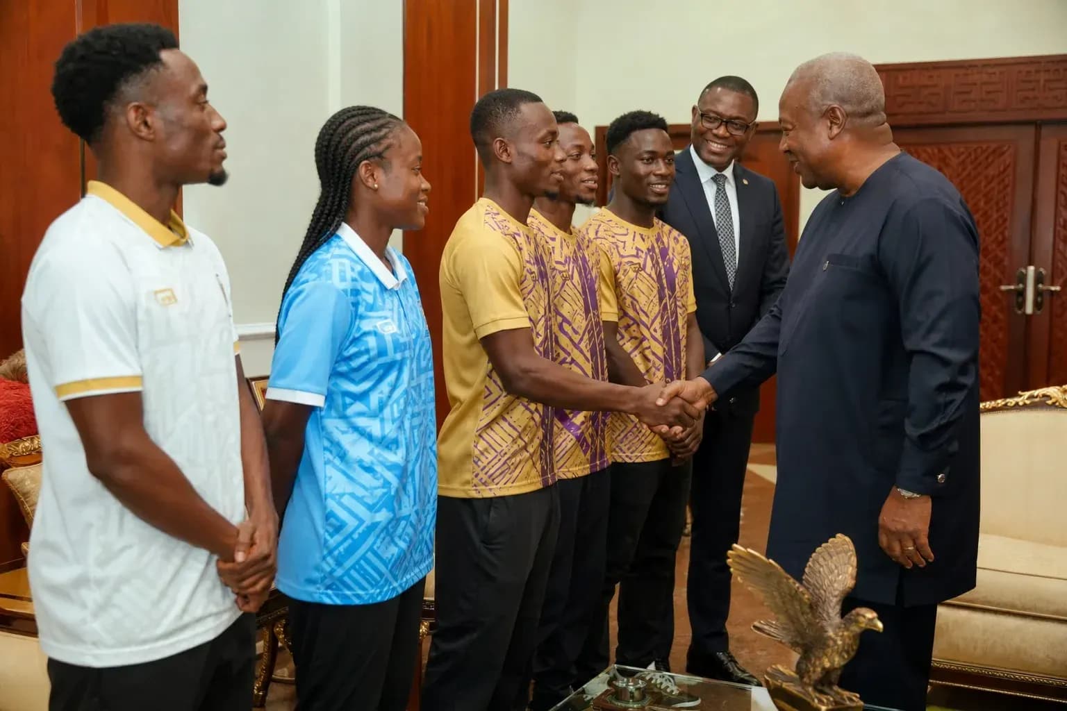 Athletes meeting official, shaking hands in office
