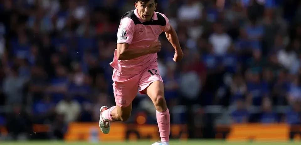 Player in pink kit sprinting with soccer ball