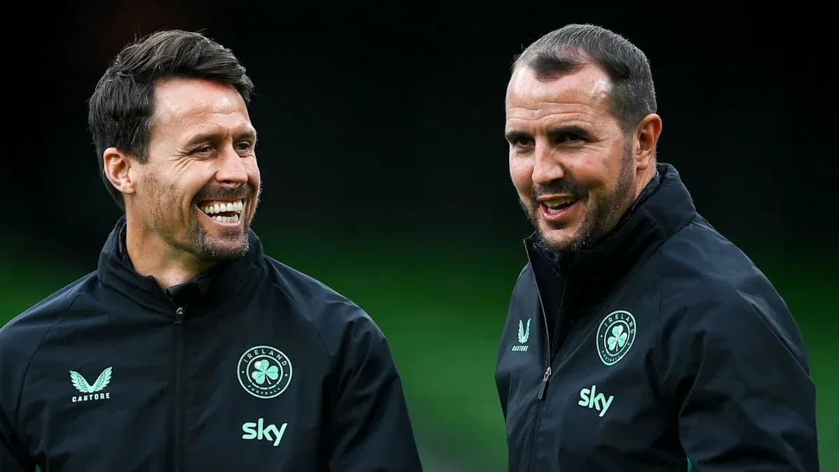 Two coaches smiling and conversing during training