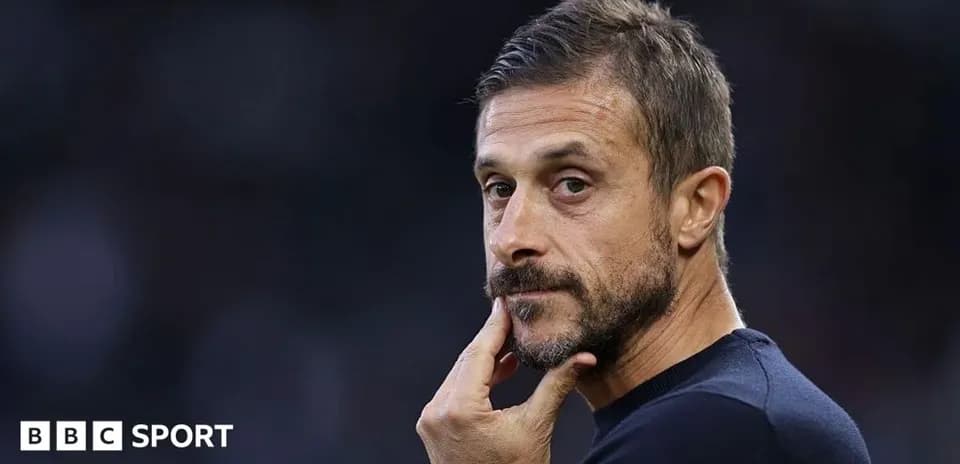 Coach pondering during a match on the sidelines