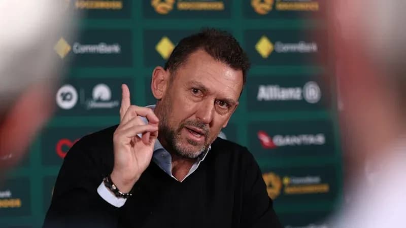 Coach speaking at press conference with gesturing hand