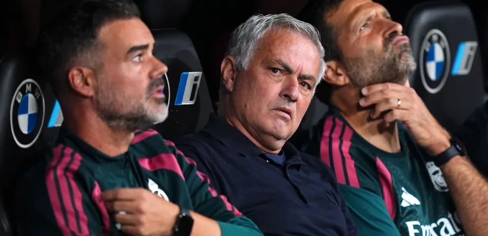 Coaching staff seated on bench during match