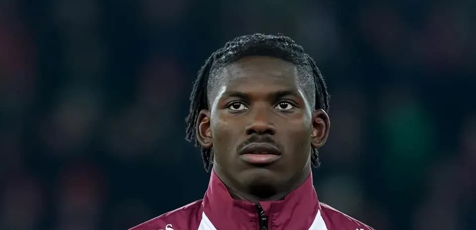 Player wearing a maroon jacket during match preparation