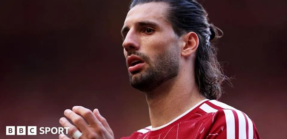 Player with long hair in red jersey during match