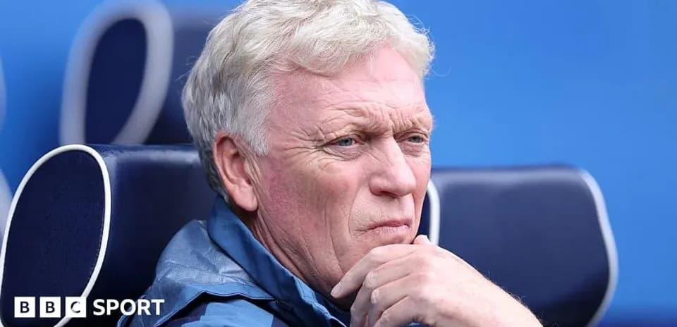 Manager seated on bench during a match