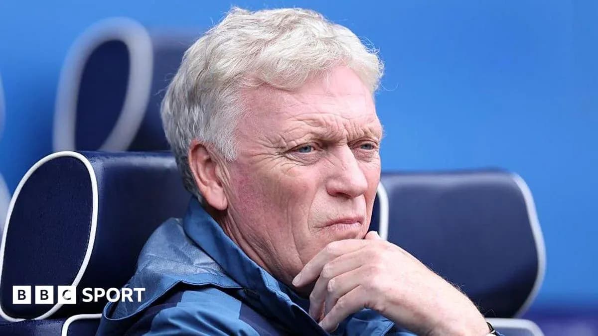 Manager seated on bench during a match
