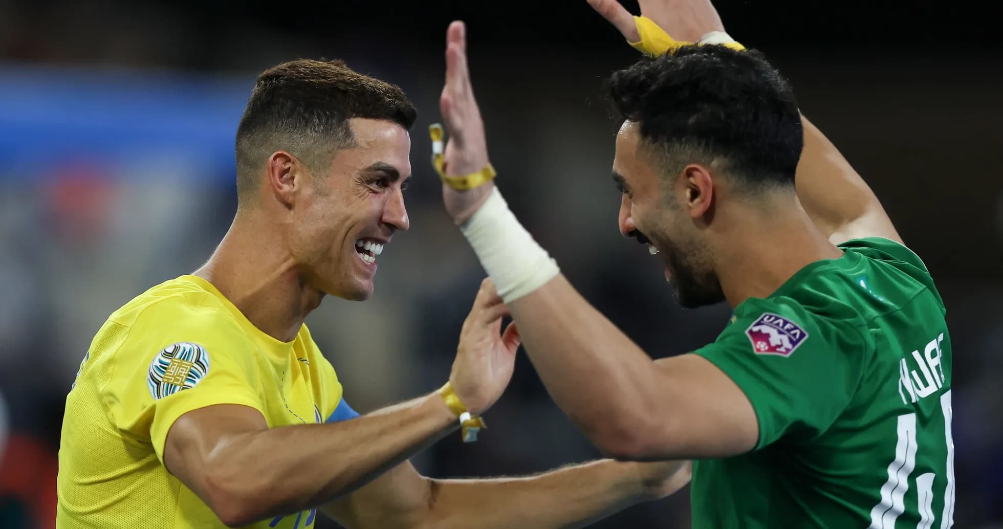 Two players celebrating a goal on the field