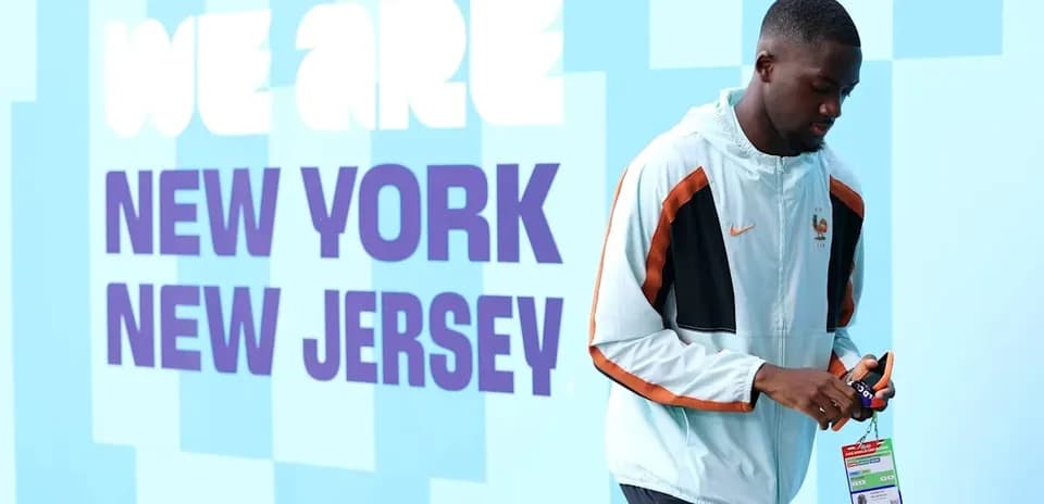 Player walking past 'We Are New York New Jersey' sign