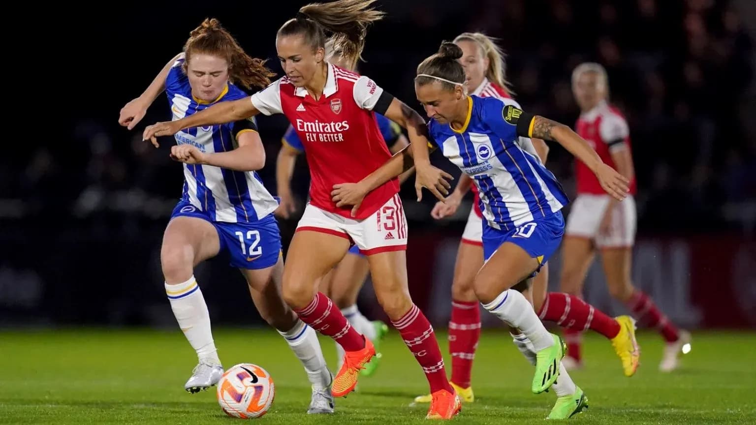Brighton W players challenging Arsenal W player for ball