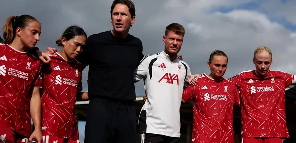 Liverpool women's team huddled together with coaches