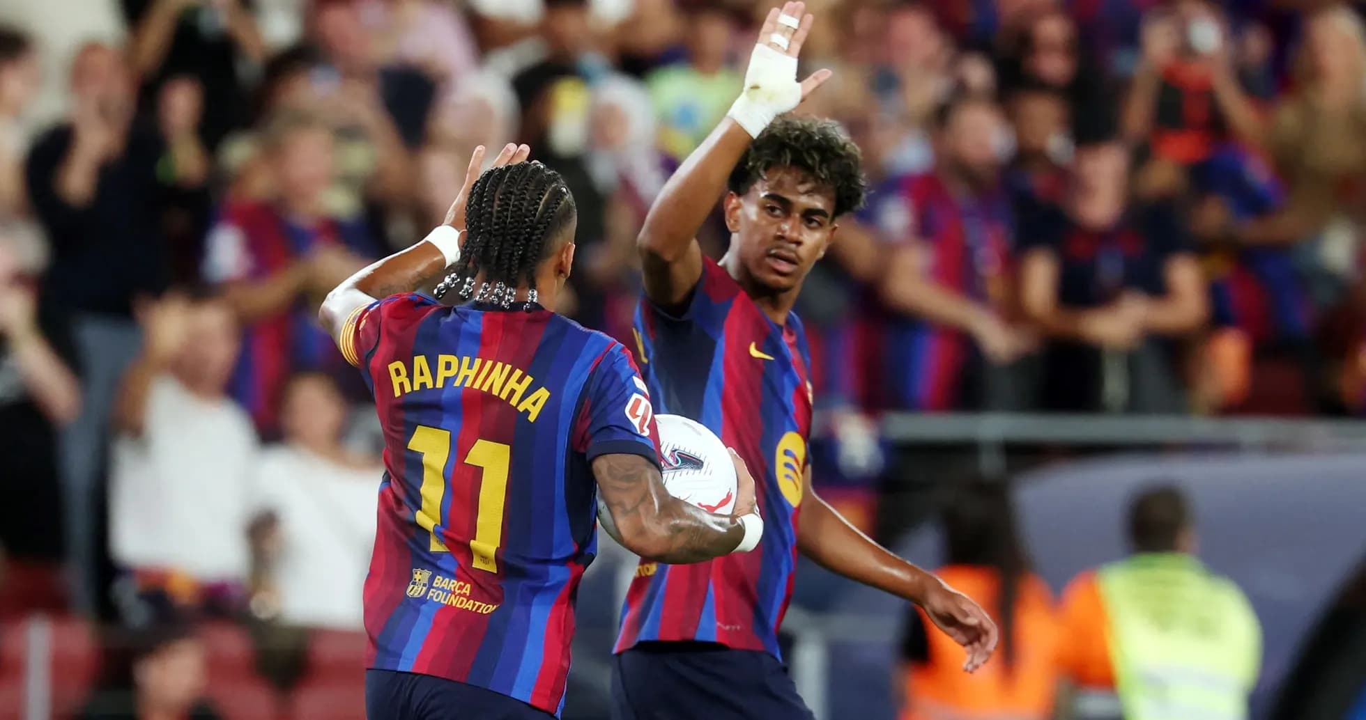 Two FC Barcelona players celebrating with a ball