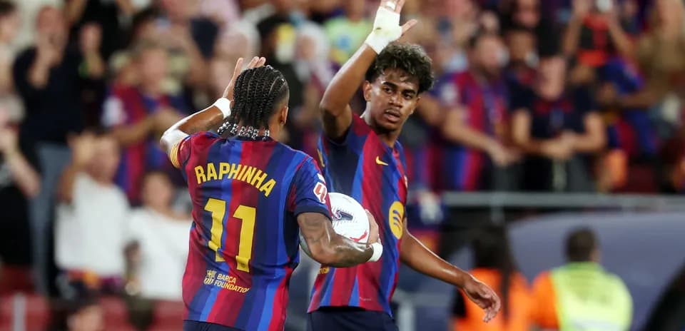 Two FC Barcelona players celebrating with a ball