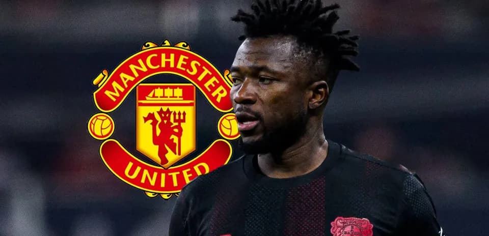 Player in black kit with Manchester United logo behind
