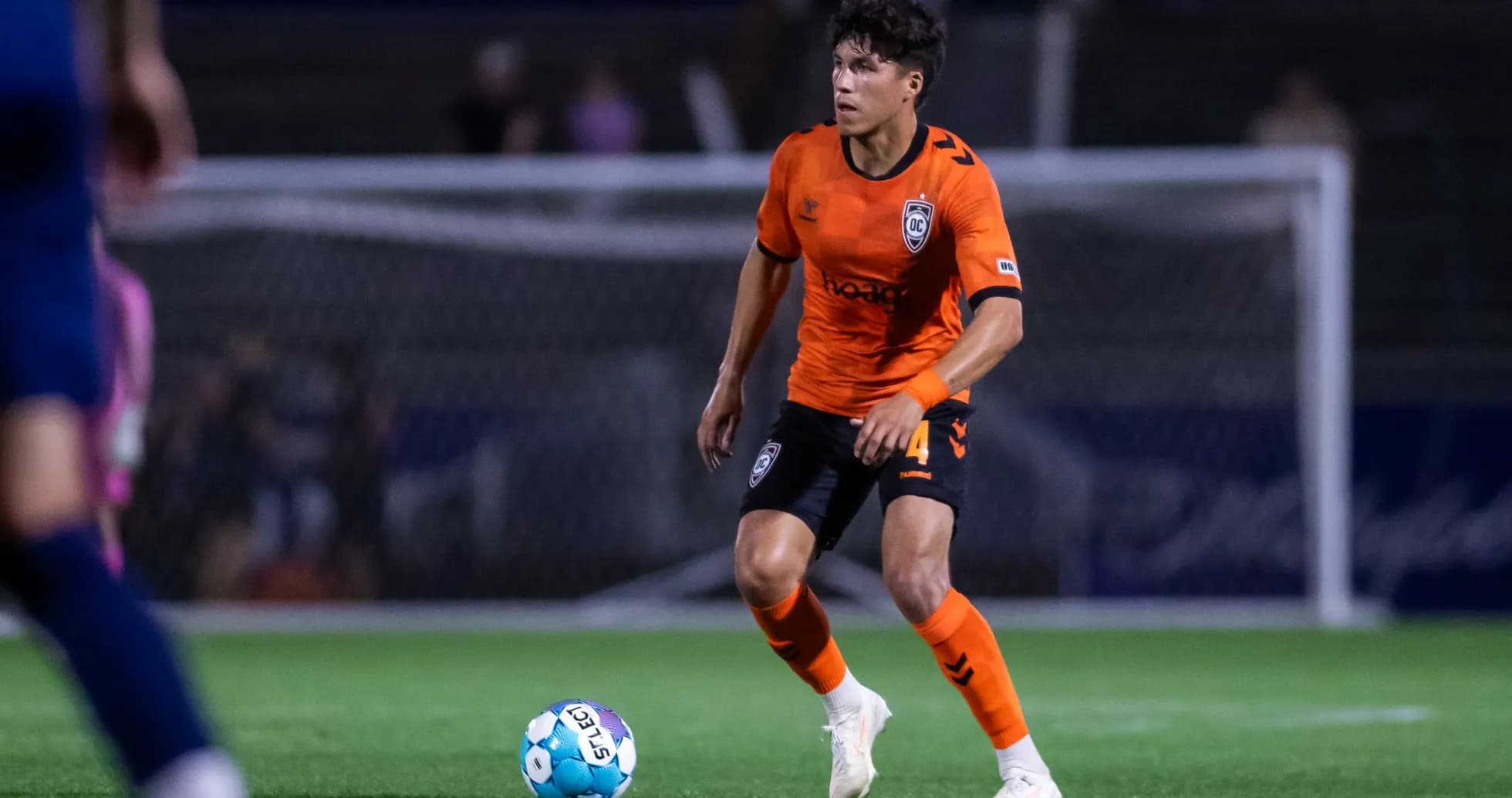 Player in orange jersey during football match
