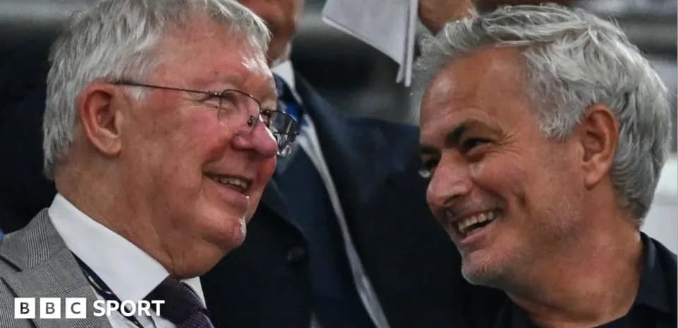Two men smiling and chatting in a stadium
