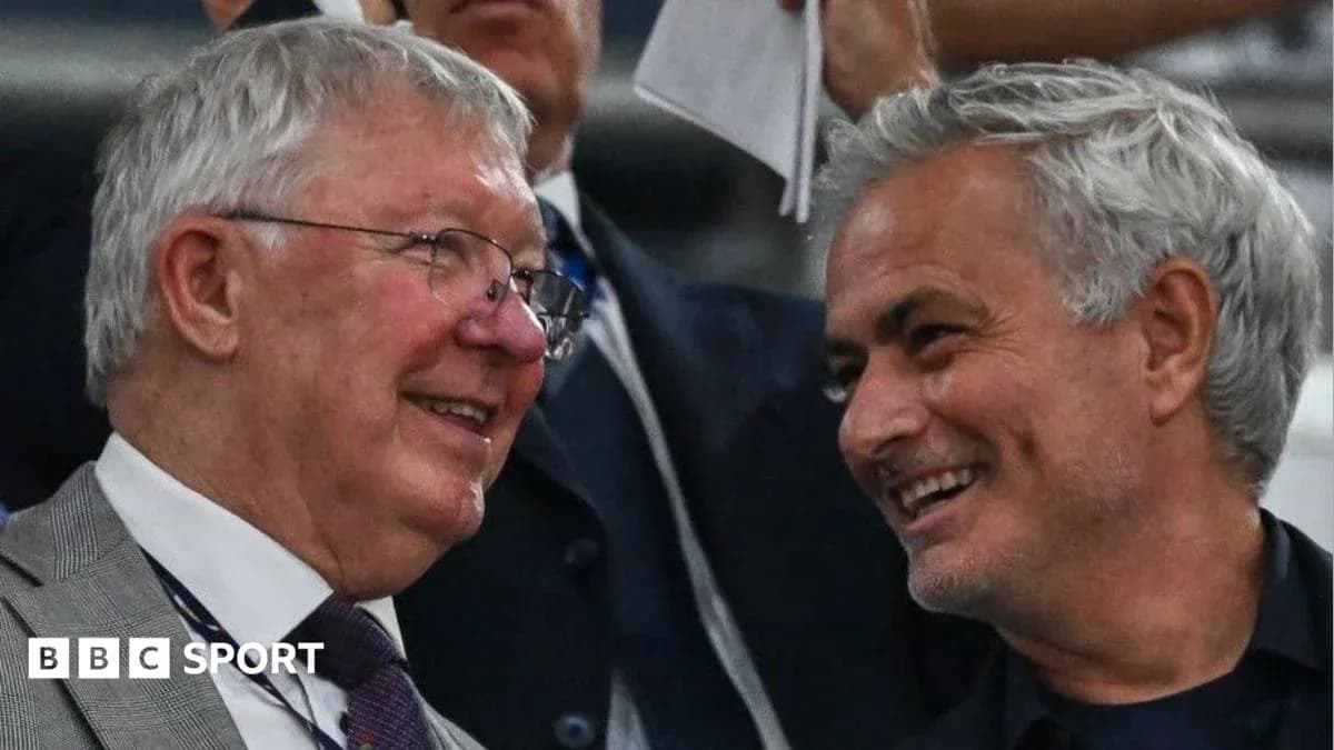 Two men smiling and chatting in a stadium