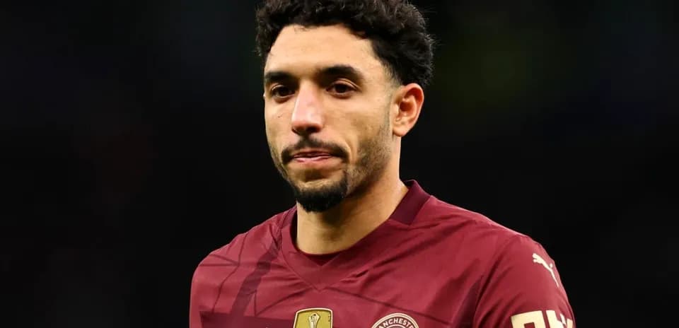 Player in maroon Manchester City jersey on field