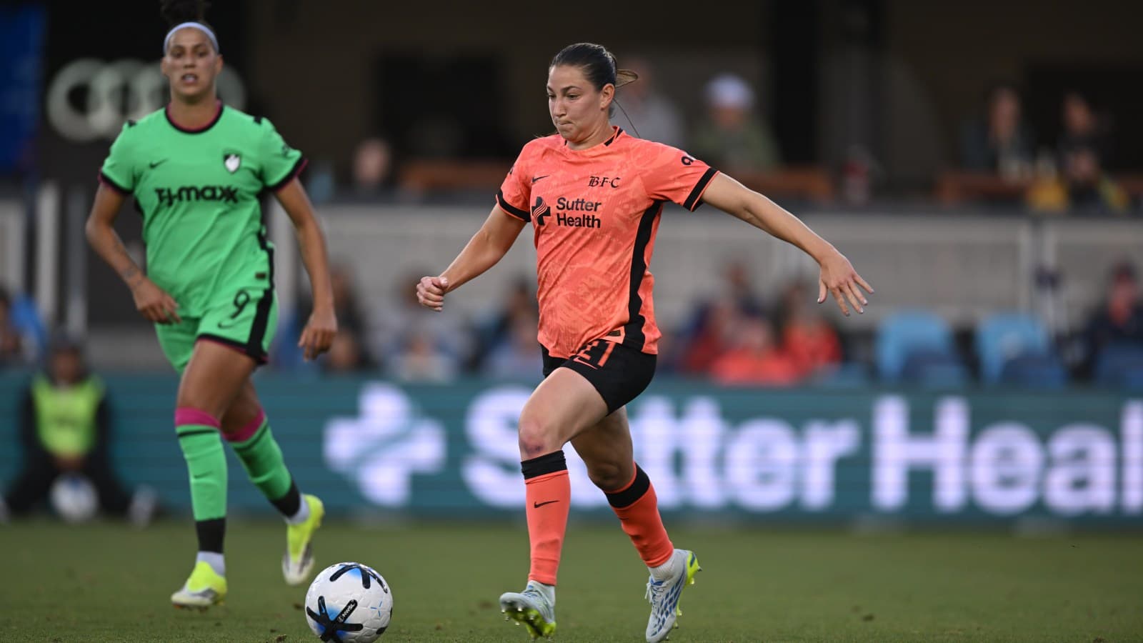 Bay FC player dribbling the ball in match