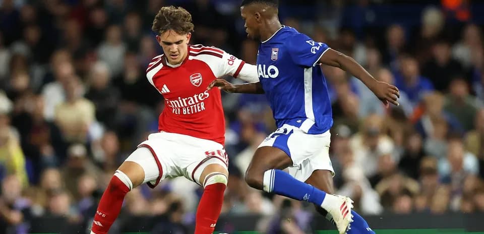 Arsenal player tackles opponent during match action