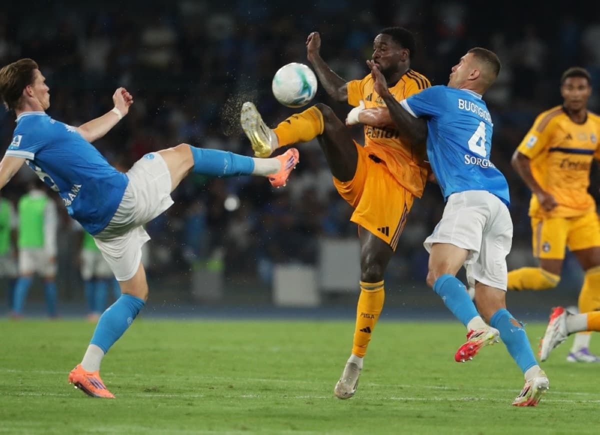 Pisa player challenging Napoli opponent for the ball
