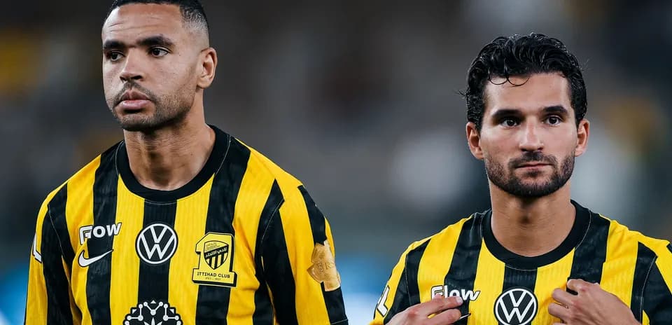 Two players in yellow and black jerseys standing together