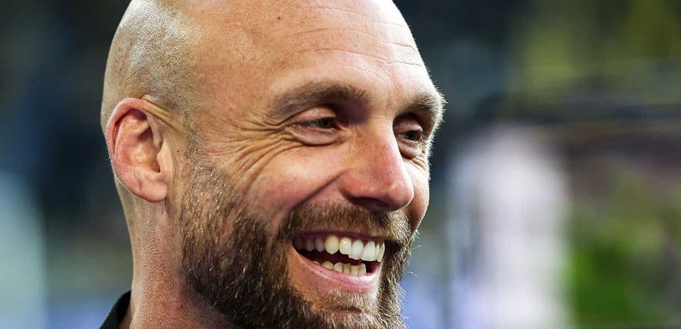 Coach smiling during a press event
