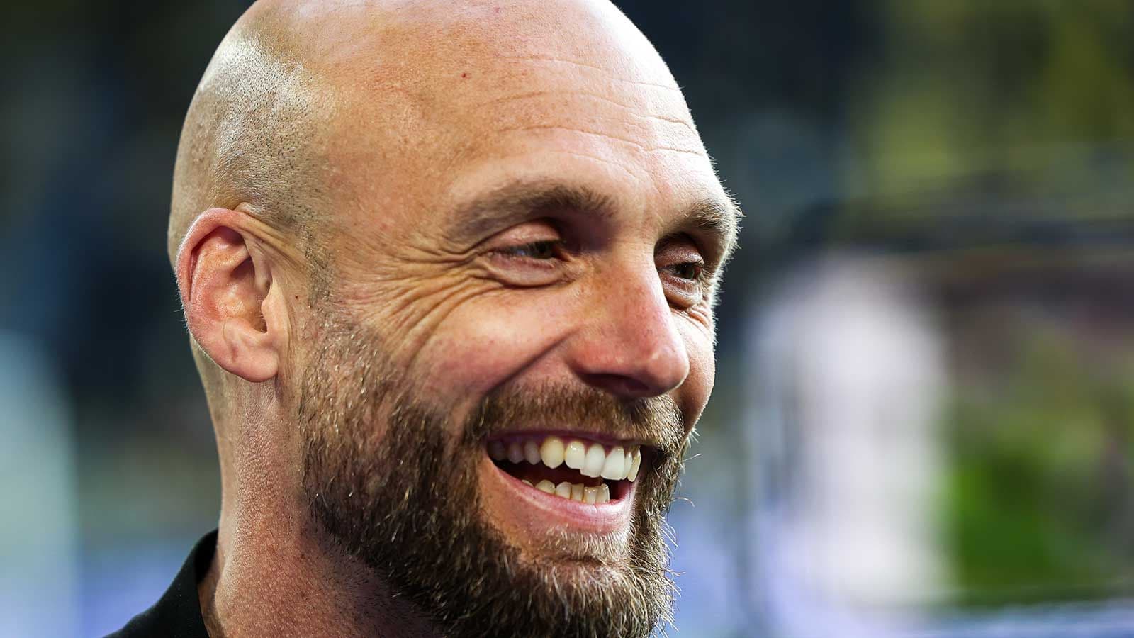 Coach smiling during a press event
