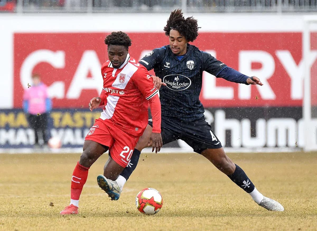 Players competing for the ball in snowy match