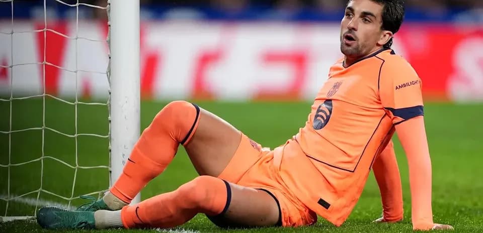 Goalkeeper sitting on the ground near the goalpost