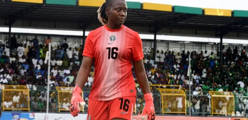 Goalkeeper in red jersey walking on the field
