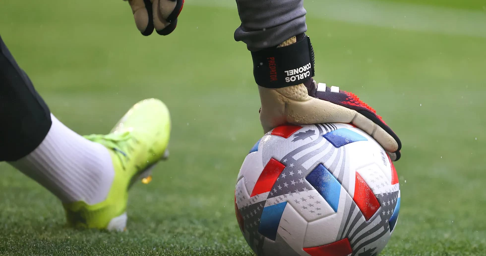 Goalkeeper's hand on soccer ball during play