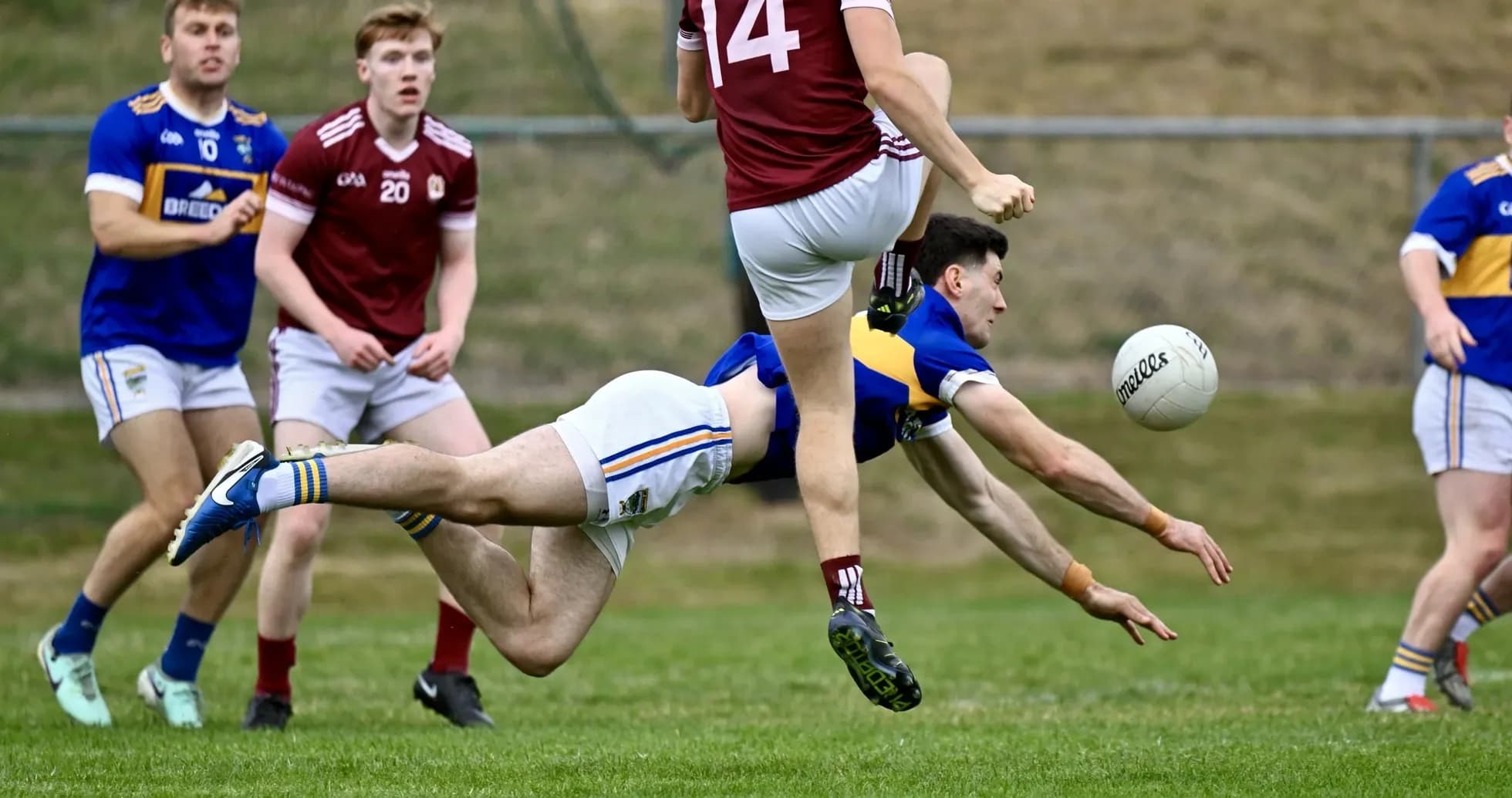 Player diving for the ball during a Gaelic football match