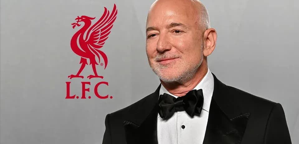 Man in tuxedo with Liverpool FC logo in background