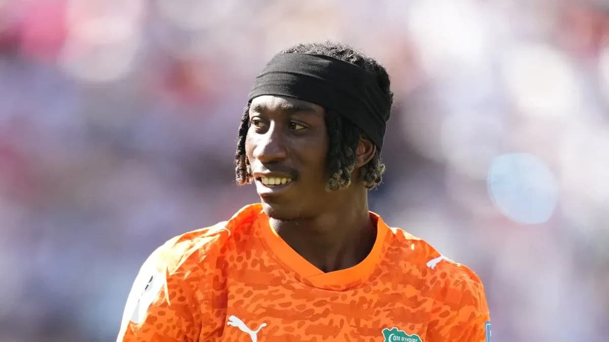 Goalkeeper in orange kit during match warm-up