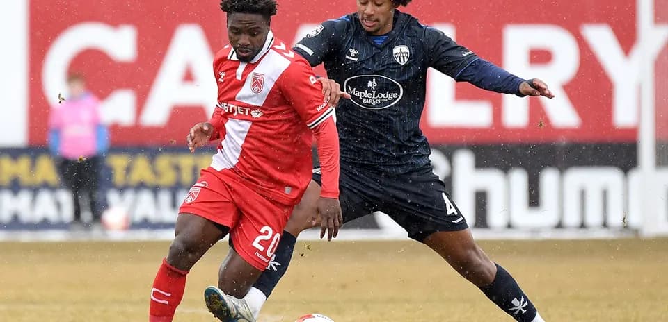 Players competing for the ball in football match