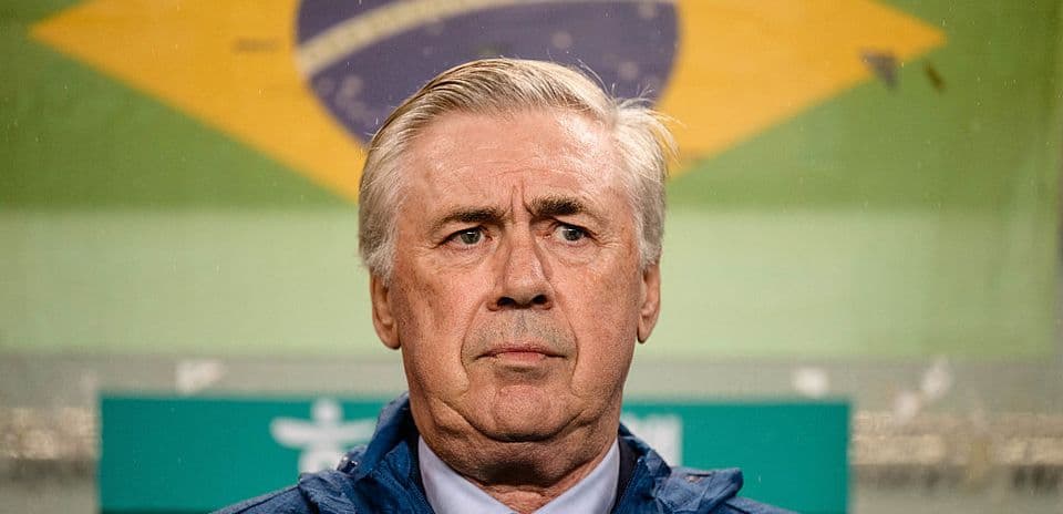 Coach standing in front of Brazilian flag backdrop