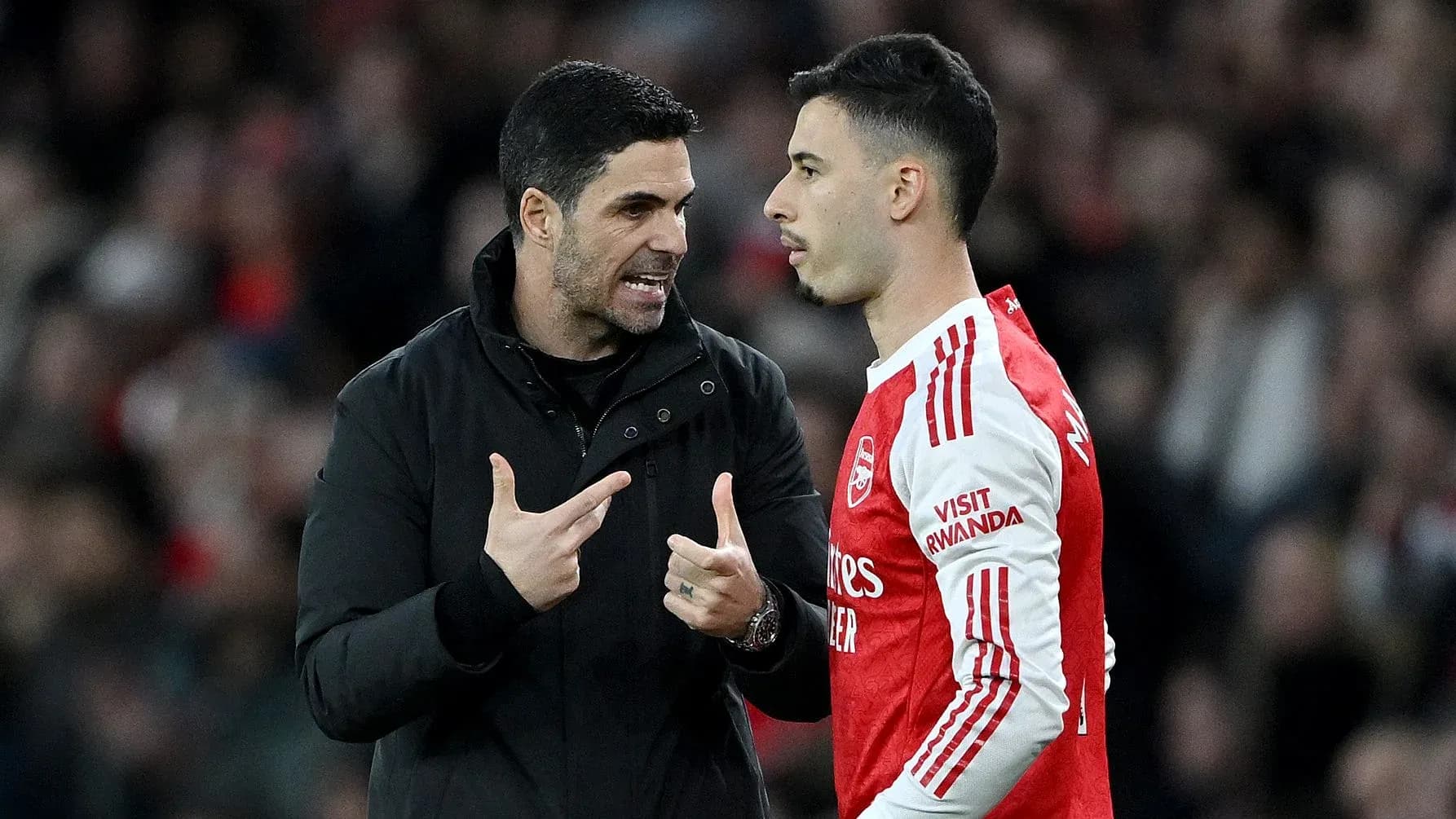 Manager discussing strategy with player during match