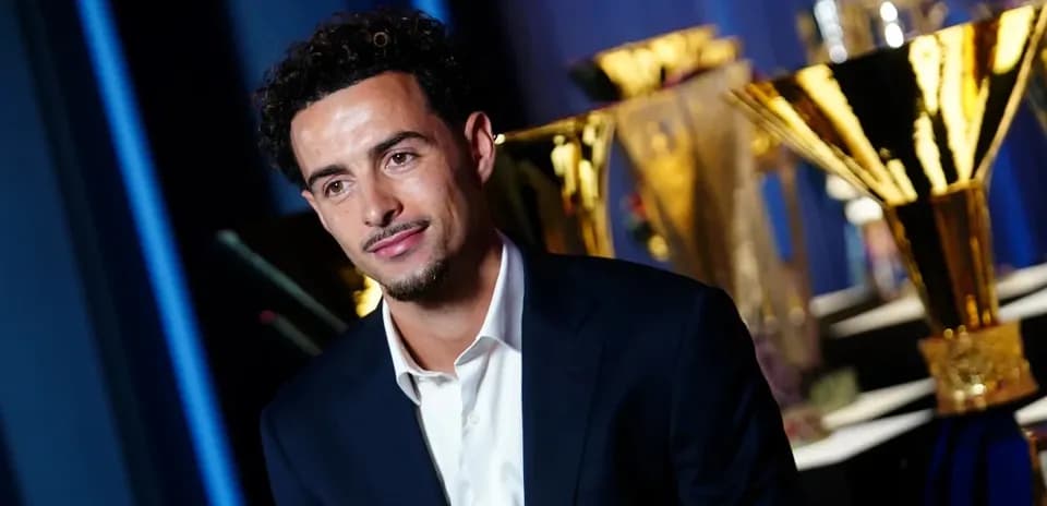 Player posing in front of trophy display